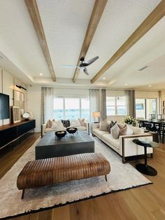 a living room filled with furniture and a flat screen tv on top of a wooden table