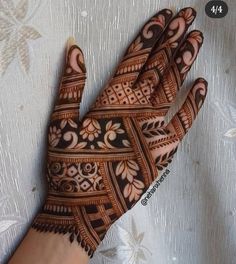 a person's hand that is decorated with henna designs on it and flowers