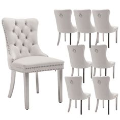 a set of six white dining chairs with buttons on the back and side, all upholstered