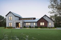 this is a computer rendering of the front elevation of a modern farmhouse style home with stone and wood accents