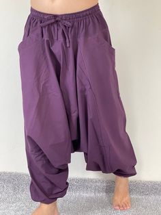 "Harem Pants Ethically Made in Thailand, Low crotch yoga pant, Unisex harem pants, Gorgeous Harem Pants, Lounge & Yoga Trousers Thai Cotton harem pants have the \"flow\", perfect for yoga or just a cool strolling. Comfort and character are what these pants are all about. They have the traditional sarong look & feel but a lot more practical when it comes to activities like yoga. As a bonus, they are convertible! Just pull them up and you get yourself a cute jumpsuit in a flash. Together w Stretch Harem Pants With Elastic Waistband For Yoga, Yoga Harem Pants With Drop Crotch, Yoga Harem Pants With Drop Crotch And Relaxed Fit, Relaxed Fit Drop Crotch Harem Pants For Yoga, Stretch Drop Crotch Harem Pants With Pockets, Baggy Yoga Pants With Drop Crotch, Baggy Solid Color Yoga Trousers, Solid Color Baggy Yoga Trousers, Cotton Harem Yoga Pants