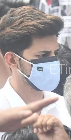 a man wearing a face mask and pointing at something in front of him with his finger