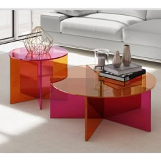 two tables with different colored glass tops in a room