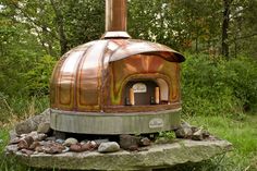 an outdoor wood fired oven sitting on top of a rock