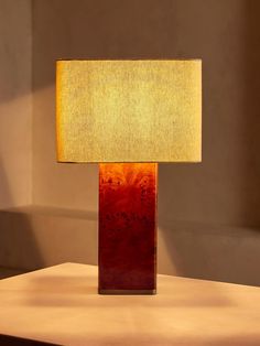 a lamp that is sitting on top of a table in front of a wall and window