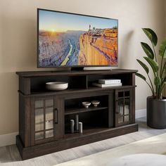 a flat screen tv sitting on top of a wooden entertainment center next to a fire place