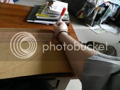 a cat sitting on top of a table next to a person