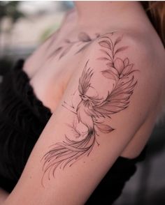 a woman with a tattoo on her arm has a bird and flower design on it