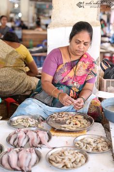 a woman sitting at a table filled with food