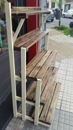 a wooden bench sitting on the side of a building