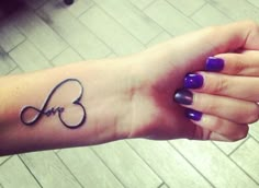 a woman's arm with the word love tattooed on it