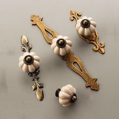 an assortment of decorative knobs and pulls on a gray surface with white flowers in the center