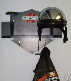 a motorcycle helmet mounted to the side of a wall with a bag hanging from it