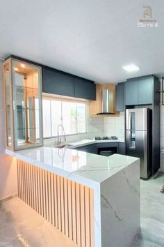 an empty kitchen with marble counter tops and stainless steel appliances in the middle of it