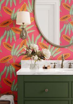 a bathroom with pink wallpaper and green cabinets