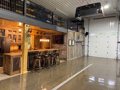 the inside of a garage with lots of counter space and bar stools in it