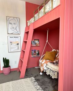 a pink bunk bed with a ladder to the top and bookshelf above it