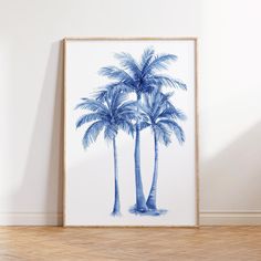 a blue and white palm tree print hangs on the wall next to a wooden floor