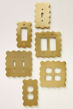 four different types of metal switch plates on a white surface with one facing the camera