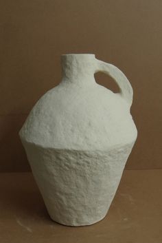 a white vase sitting on top of a table