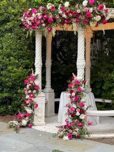 an outdoor wedding ceremony with pink and white flowers on the arbor, surrounded by greenery