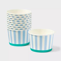 blue and white striped paper cups stacked on top of each other in front of a white background