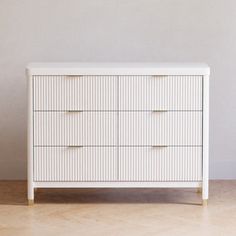 a white dresser sitting on top of a hard wood floor