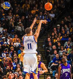 two basketball players are jumping for the ball in front of an arena full of people