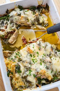 a casserole dish with chicken, spinach and cheese