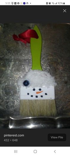 an image of a snowman with a red hat on top of a paintbrush