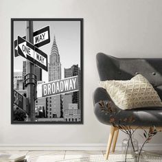 a black and white photo of a street sign in front of a cityscape