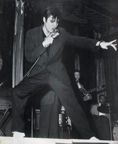 elvis presley performing on stage with his guitar