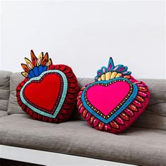 two decorative pillows sitting on top of a couch