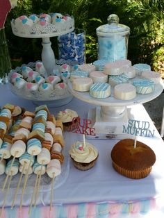 an assortment of cupcakes and muffins on a table with other desserts