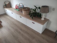 a white shelf with some plants on top of it