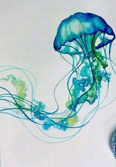 a blue and green jellyfish floating in the water with bubbles on it's back