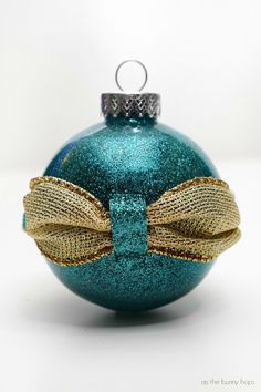 a blue ornament with a gold bow on it