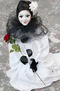 a creepy doll sitting on the ground with a rose in it's hand,