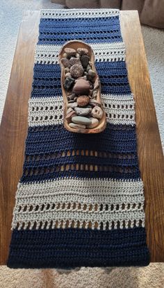 a crocheted table runner with a bowl of rocks in it on the floor