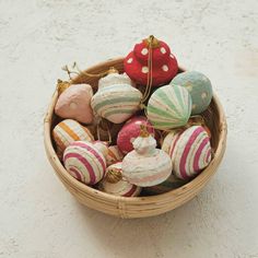 a basket filled with lots of colorfully decorated eggs on top of a white floor