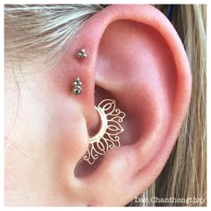 a woman with ear piercings in the shape of a crescent and stars on her ears