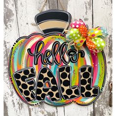 a sign that says hello fall hanging on the side of a wooden door with polka dots