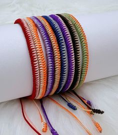 multicolored bracelets are arranged on top of a white roll