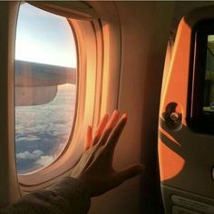 an airplane window with the view of clouds and water from it's seat area