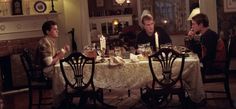 three men sitting at a dinner table with candles in their hands