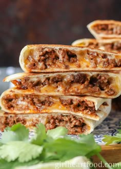 three burritos stacked on top of each other with meat and cheese in them