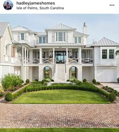 a large white house with lots of windows on it's front porch and landscaping