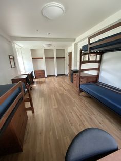 a room with bunk beds, desks and other items in the room that is empty