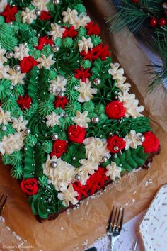 a decorated cake sitting on top of a wooden cutting board next to a knife and fork