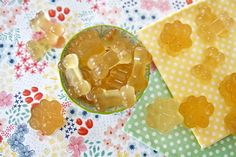 two bowls filled with gummy bears sitting on top of a flowered table cloth